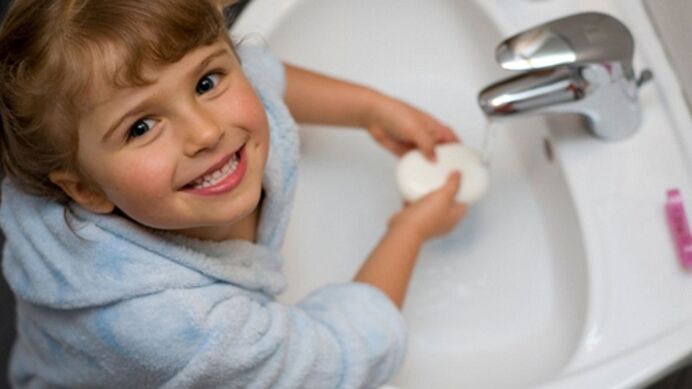 child washes hands with soap to avoid worms
